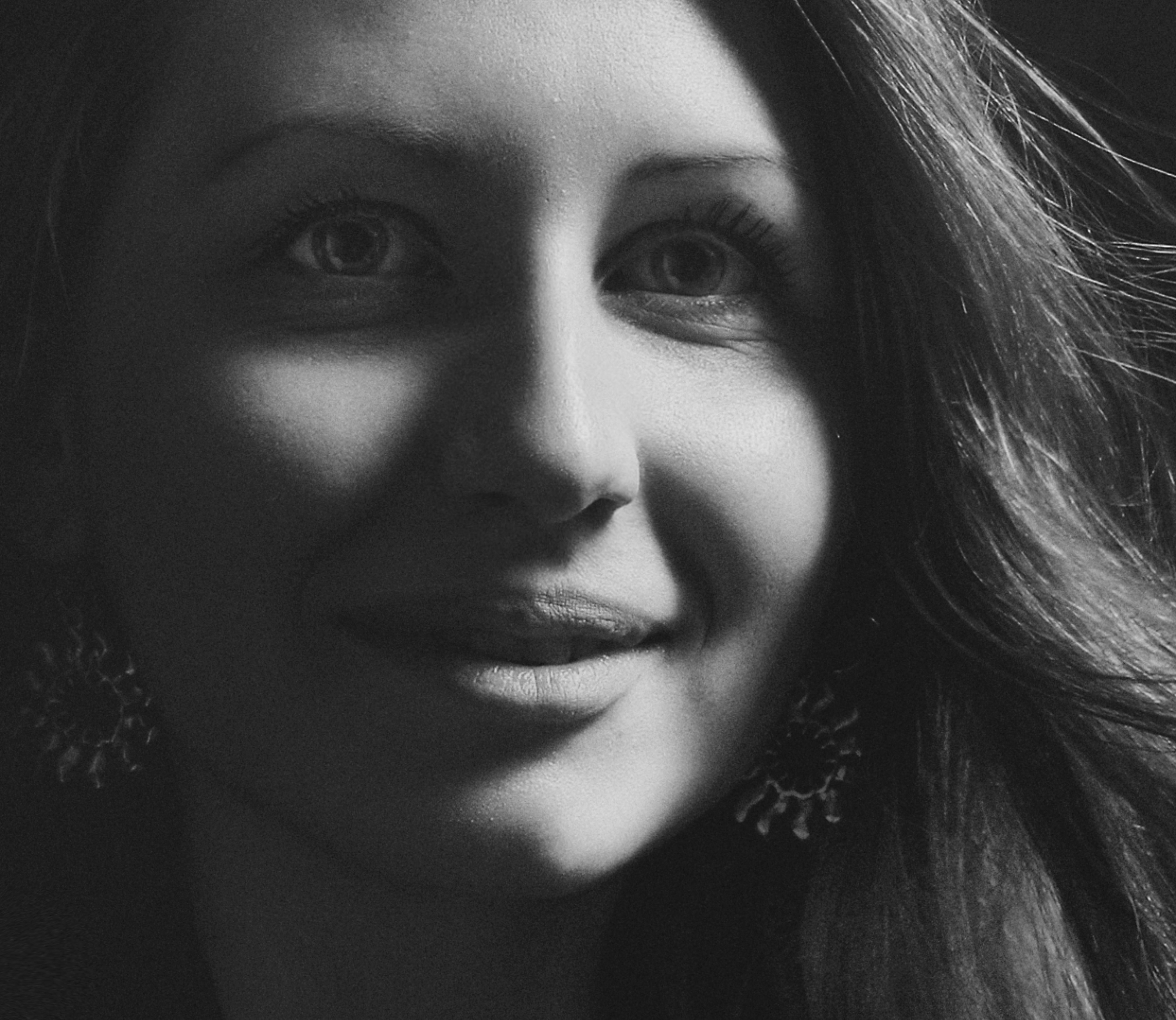 Charming black and white portrait of a smiling woman with expressive eyes.