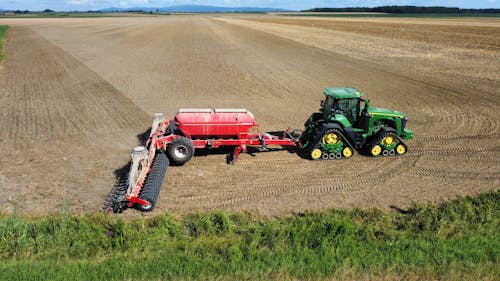 An Aerial Photography of a Tractor on Brown Field