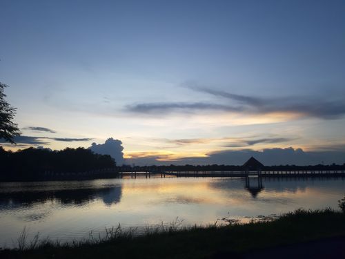 Free Peaceful dusk over a Thai lake with reflections and a bridge. Stock Photo