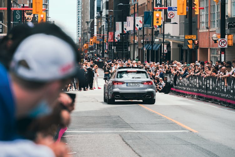 Car Driving Beside The Crowd