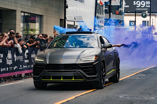 People Looking at the Super Car on the Road with Smoke Bomb