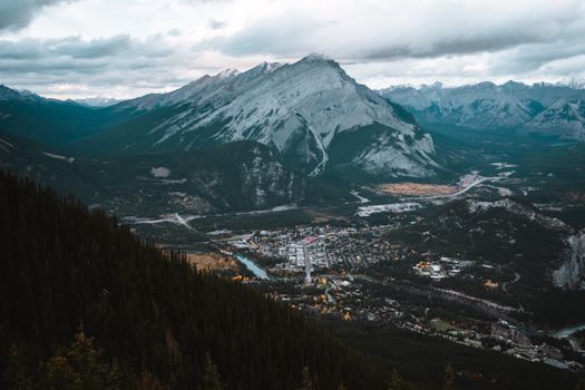 A breathtaking aerial view of a mountain town nestled in a scenic valley surrounded by towering peaks.