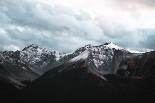 Snow-covered peaks under a cloudy sky in Banff National Park, Canada.