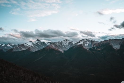 Breathtaking view of a snow-capped mountain range under a twilight sky, showcasing nature's beauty.