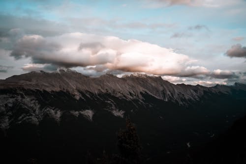 Free Photo of Snow Capped Mountains Under Cloudy Sky Stock Photo