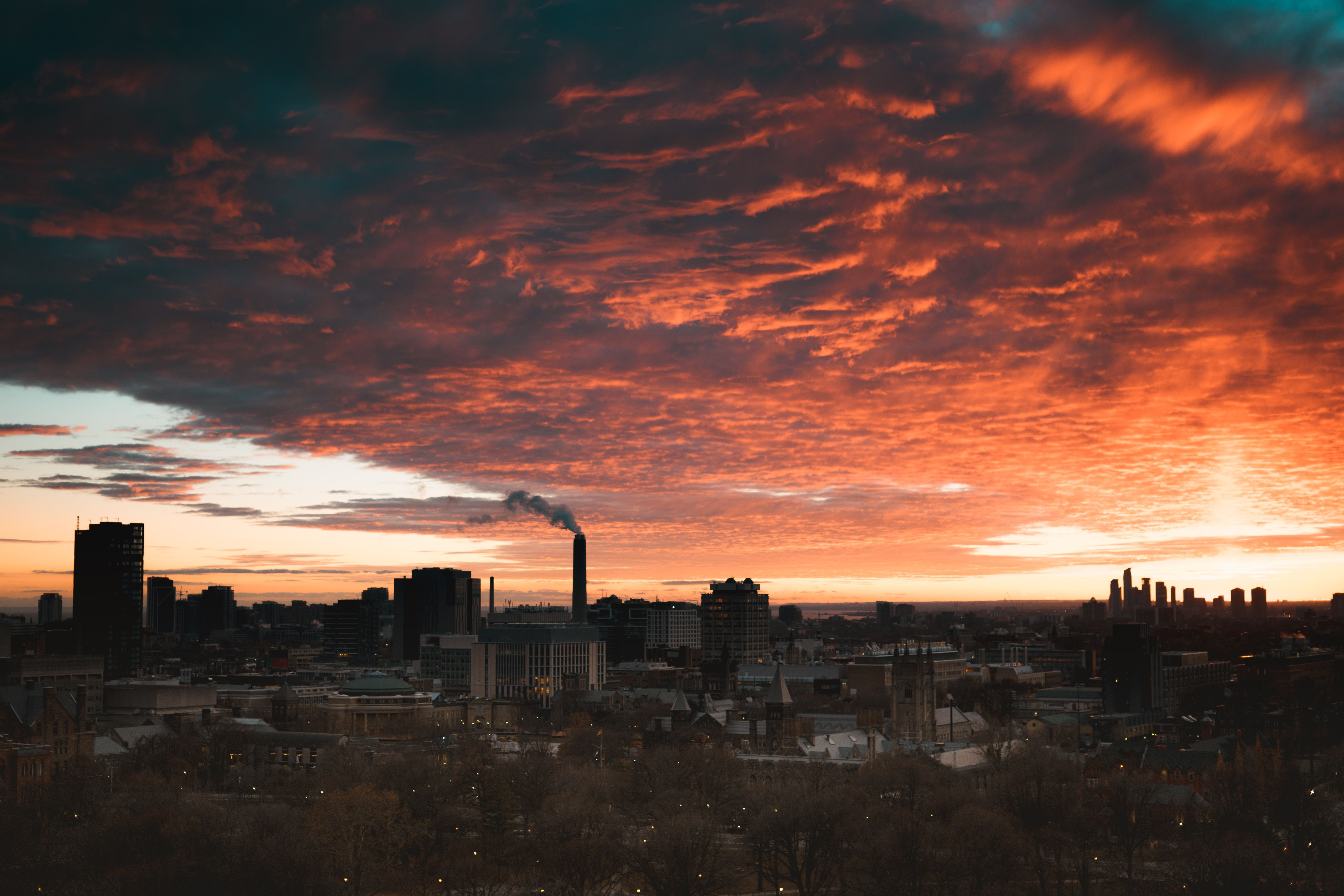 Capture of Toronto's skyline during a vibrant sunset with dramatic clouds and cityscape silhouette.