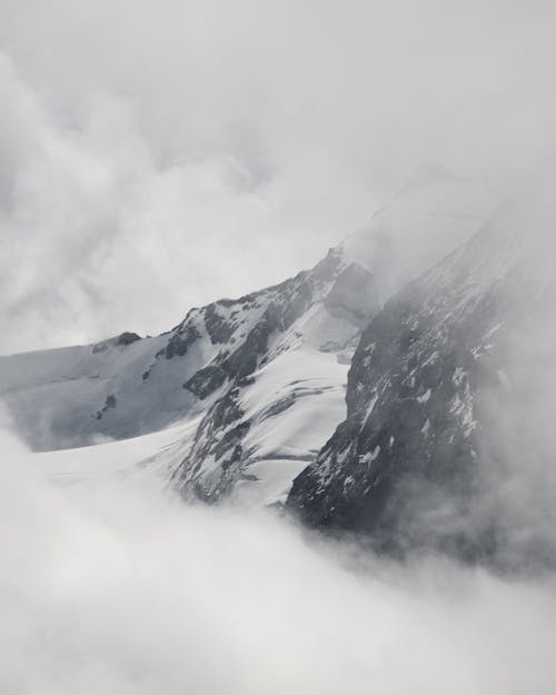 Snow Covered Mountain Under Cloudy Sky