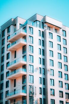 Stunning modern high-rise building with glass balconies and concrete facade.