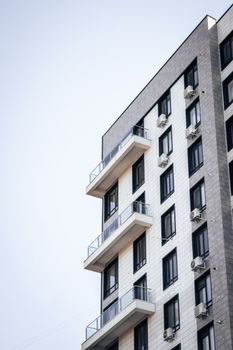 Contemporary high-rise building with balconies against a clear sky.