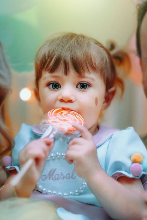 Free Girl in Pink and White Shirt Holding White and Blue Plastic Toy Stock Photo