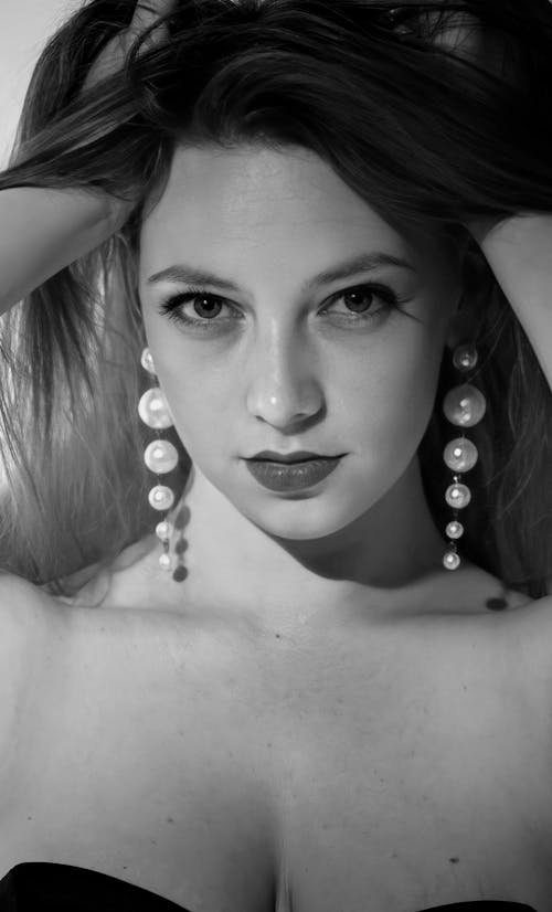 Grayscale Photo of a Beautiful Woman Wearing Pearl Earrings 