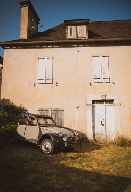 Classic car parked by an abandoned house, evoking nostalgia and retro vibes.