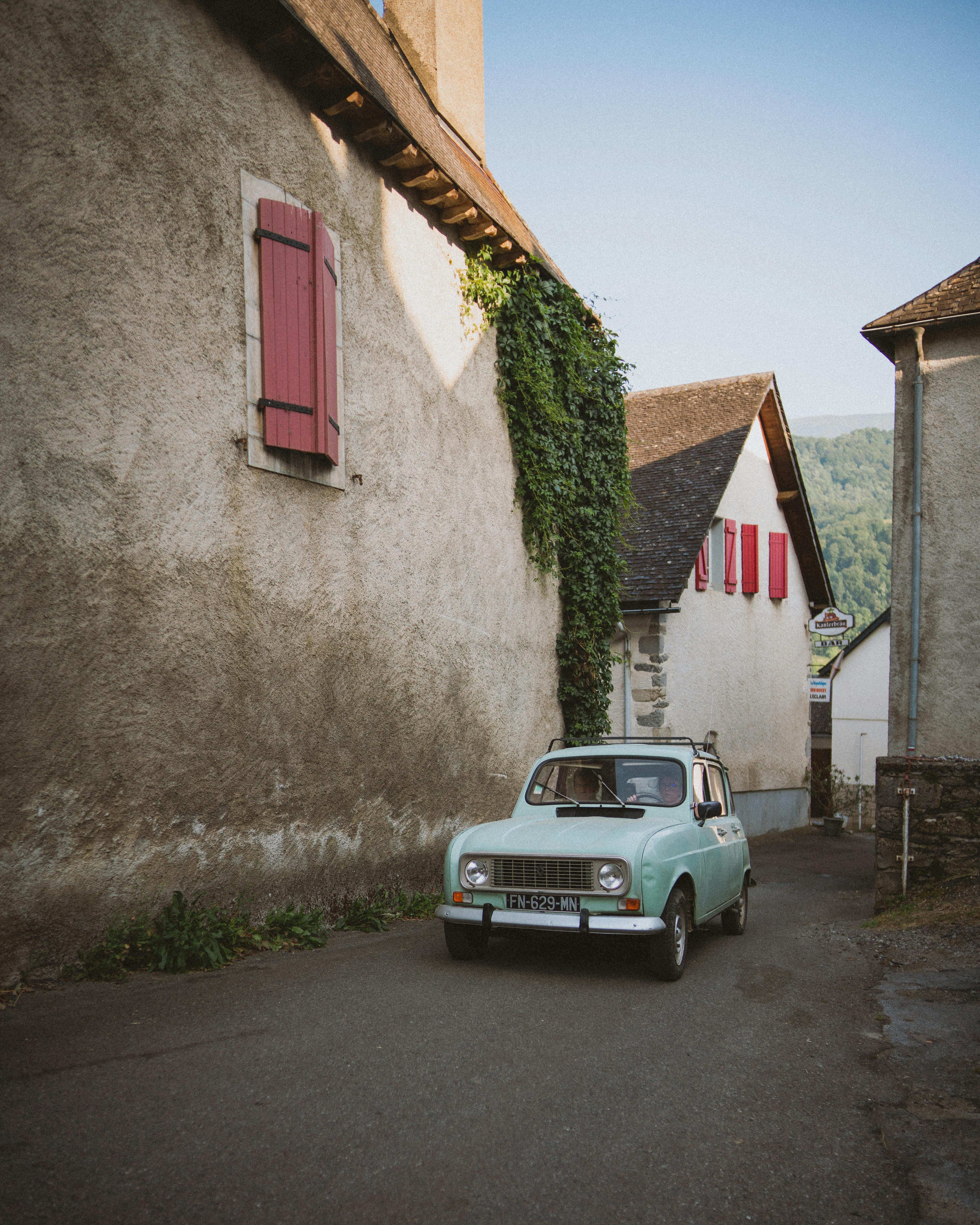 A classic car parked on a scenic street in a quaint European village, evoking timeless charm and nostalgia.