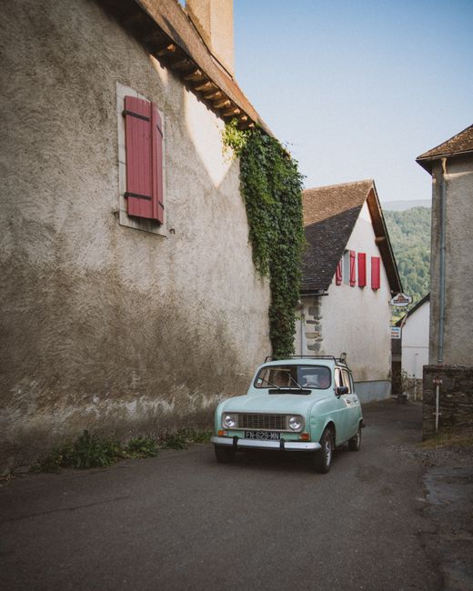 A classic car parked on a scenic street in a quaint European village, evoking timeless charm and nostalgia.