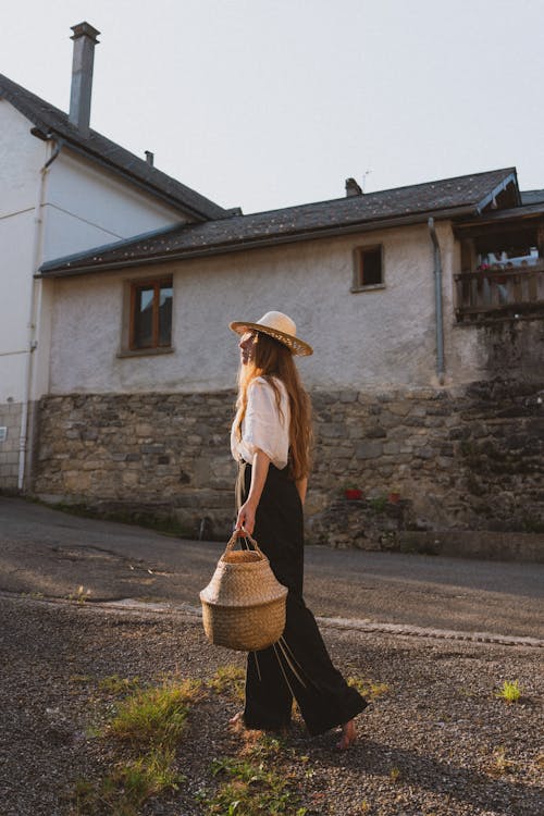 Woman Wearing Straw Hat on Village Street