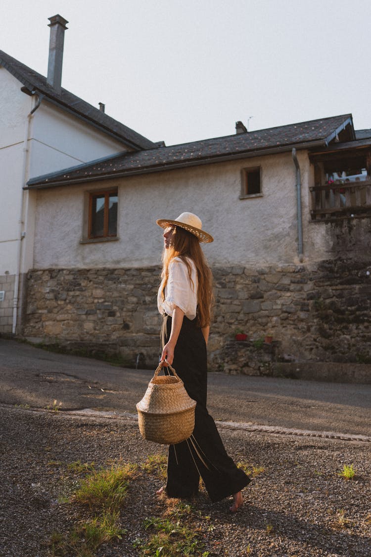 Woman Wearing Straw Hat On Village Street