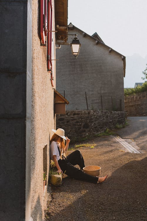 Woman Wearing Straw Hat on Village Street