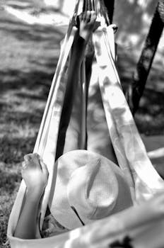 A person lying down in a hammock outdoors, enjoying the sun in General Roca, Argentina.