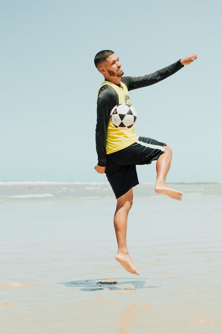 Man Playing Soccer At The Beach