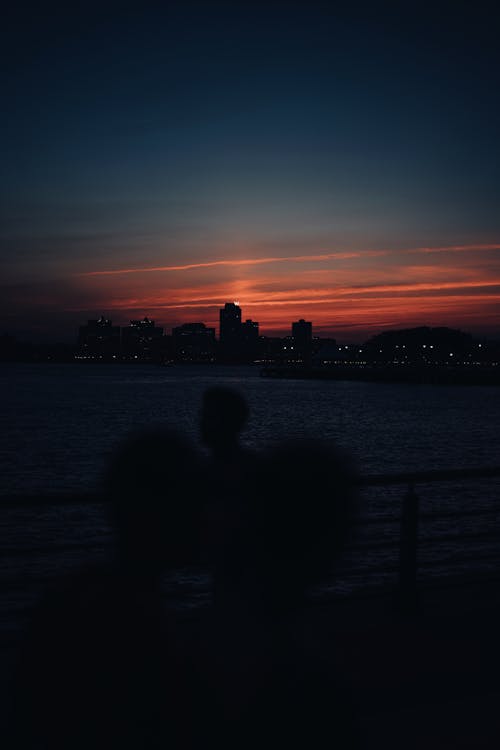 Silhouette of Person Standing on Bridge during Sunset