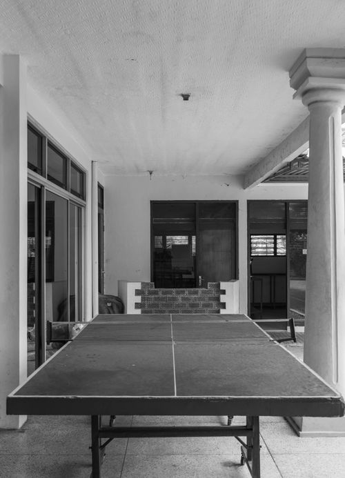 Free A monochrome image of a ping pong table set in an outdoor veranda space. Stock Photo