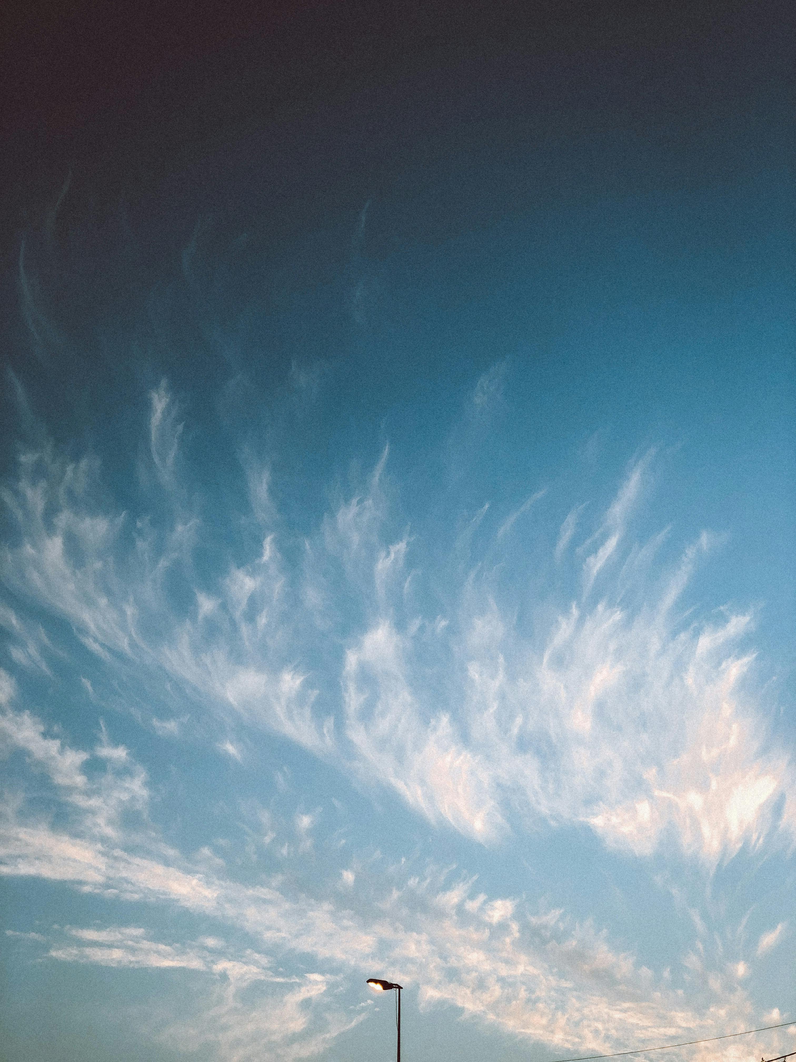A serene view of wispy clouds in a clear summer sky, ideal for weather-related concepts.