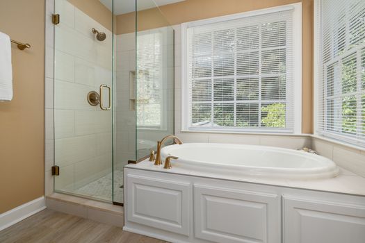 Luxurious bathroom with modern amenities, featuring a bathtub and a glass shower.