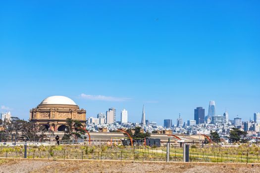 San Francisco cityscape featuring the iconic Palace of Fine Arts and skyline under a clear blue sky.