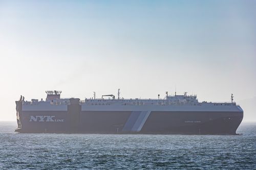 Free A massive cargo ship traversing the calm sea under a clear sky. Stock Photo