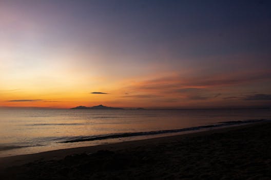Experience a tranquil sunrise over the calm waters on a beach in Da Nang, Vietnam.