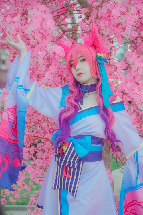 Woman in a Cosplay Costume Posing Near Pink Flowers
