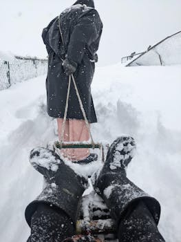A winter scene of sledding in snowy Gulmarg, featuring snow-covered slopes and people enjoying the chill.