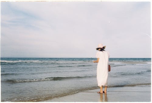Free Woman in White Dress Standing on Beach Stock Photo