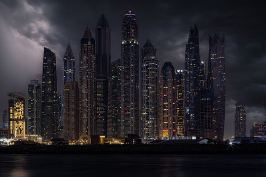 Majestic skyscrapers of Dubai's skyline brilliantly lit during the night.