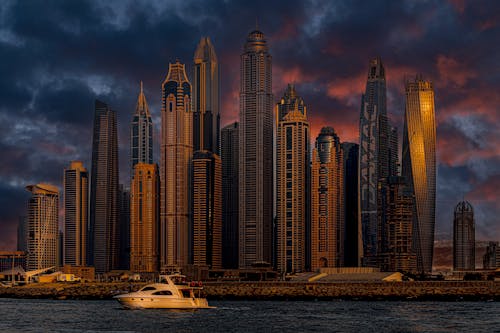 White Boat on Body of Water Near High Rise Buildings