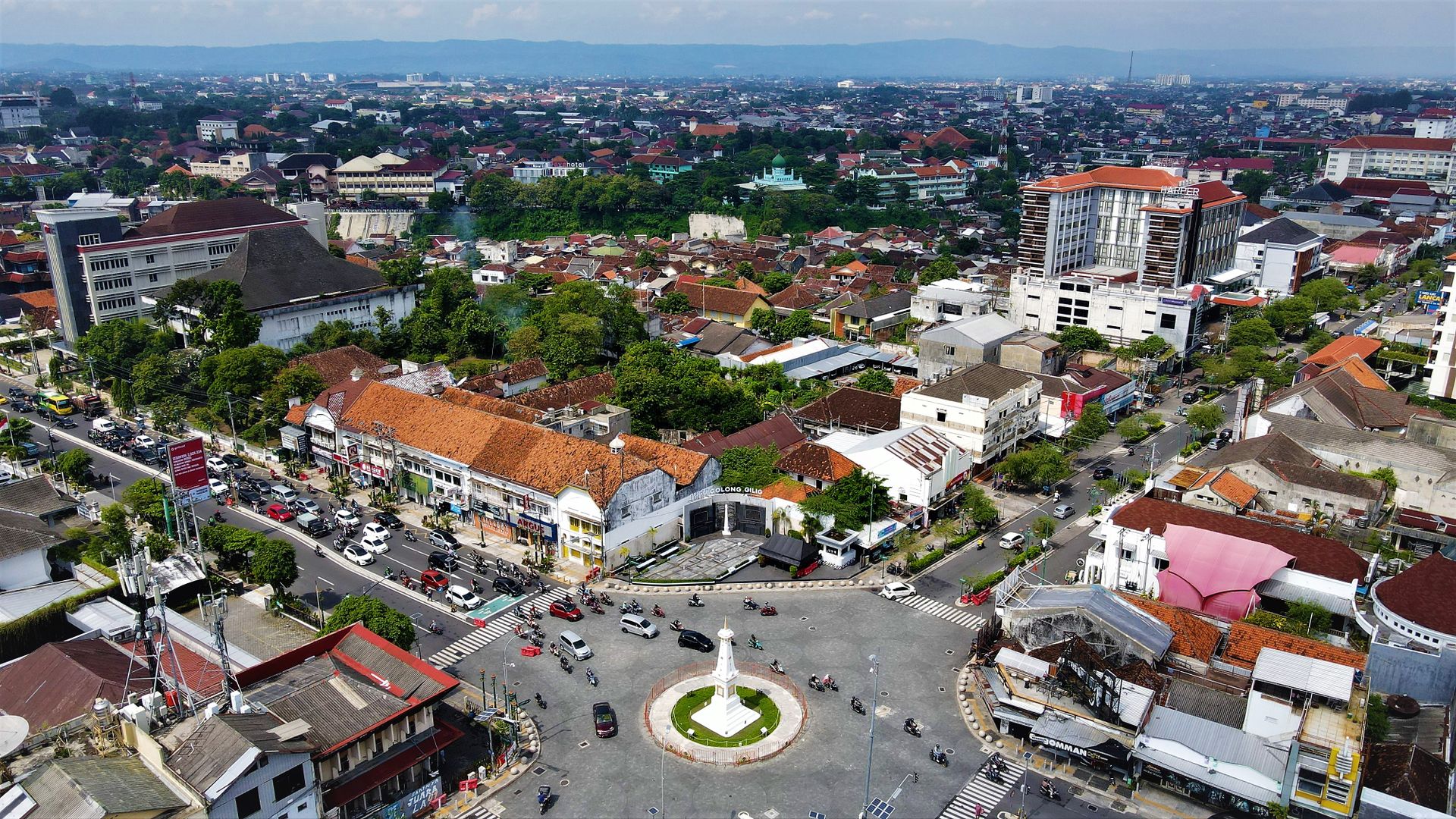 Explore an aerial cityscape of Yogyakarta, featuring the iconic Yogyakarta Monument and bustling urban streets.