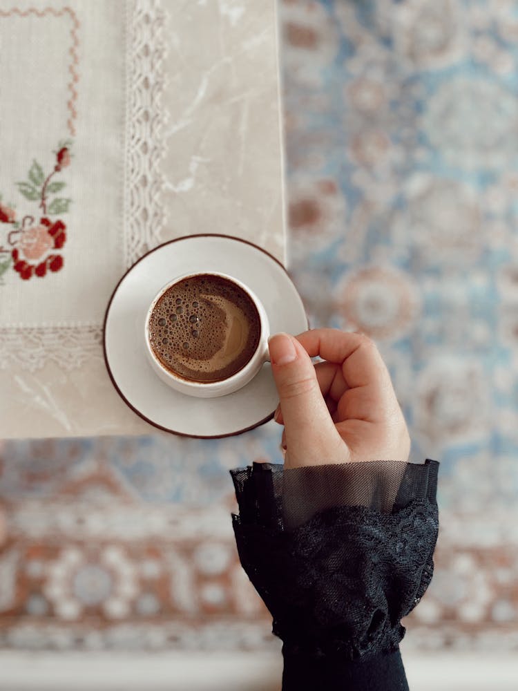 Woman Hand With Black Coffee In Cup On Table