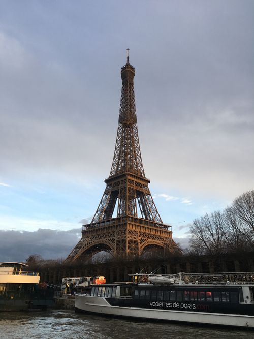 Free Iconic Eiffel Tower captured in Paris with boats on Seine River. Stock Photo