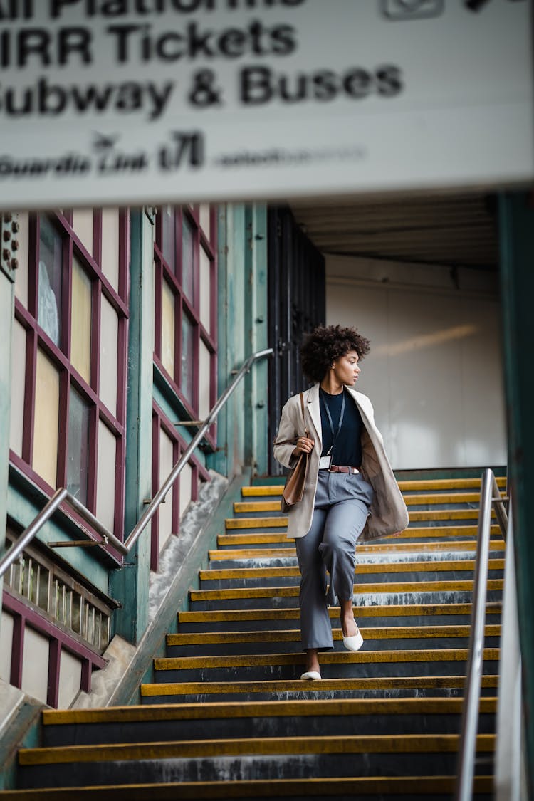 Woman Walking Down Steps At A Subway Station