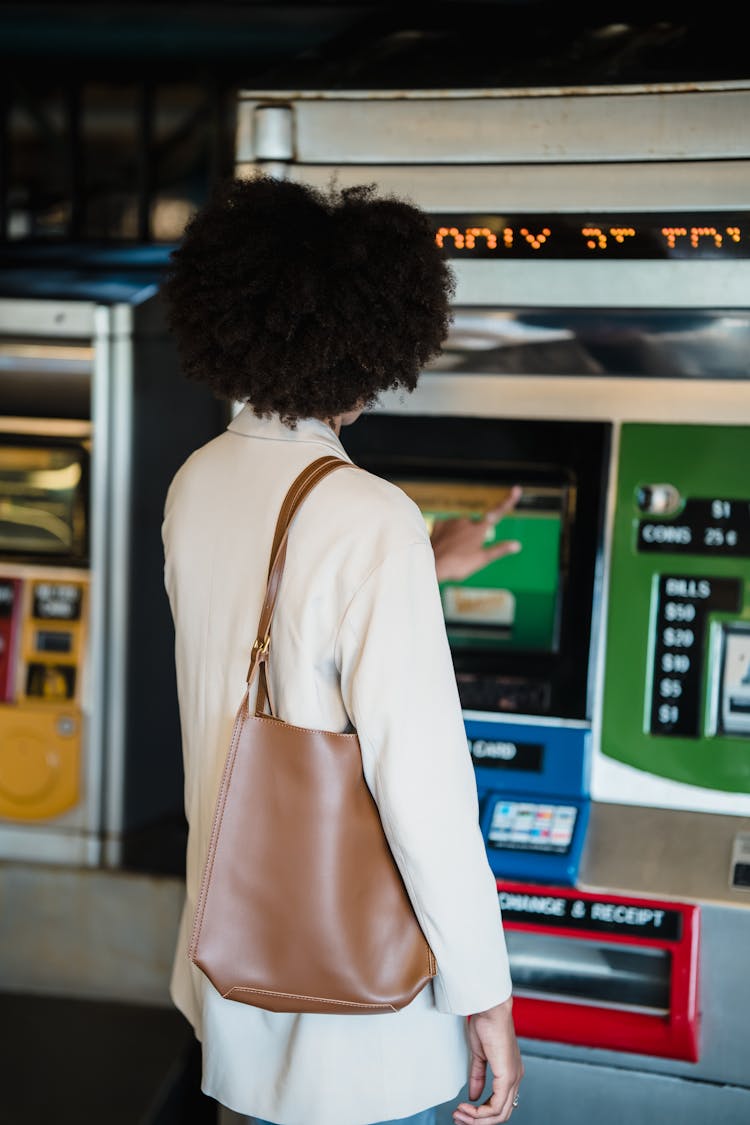 Woman Buying A Public Transport Ticket At A Ticket Machine