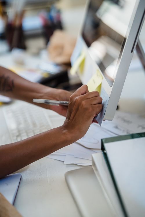 Hand Writing on a Sticky Note on a Computer Monitor · Free Stock Photo