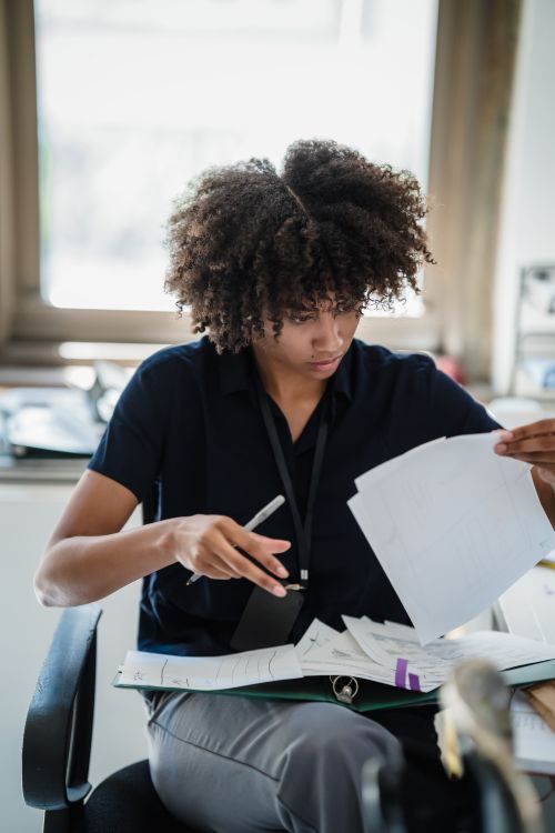 Free A professional woman reviews business documents, highlighting work focus. Stock Photo