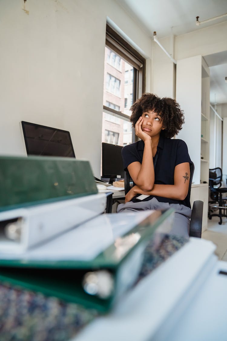 Woman Sitting In Office And Thinking