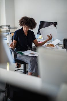 Focused woman reviewing documents in a modern office setting.