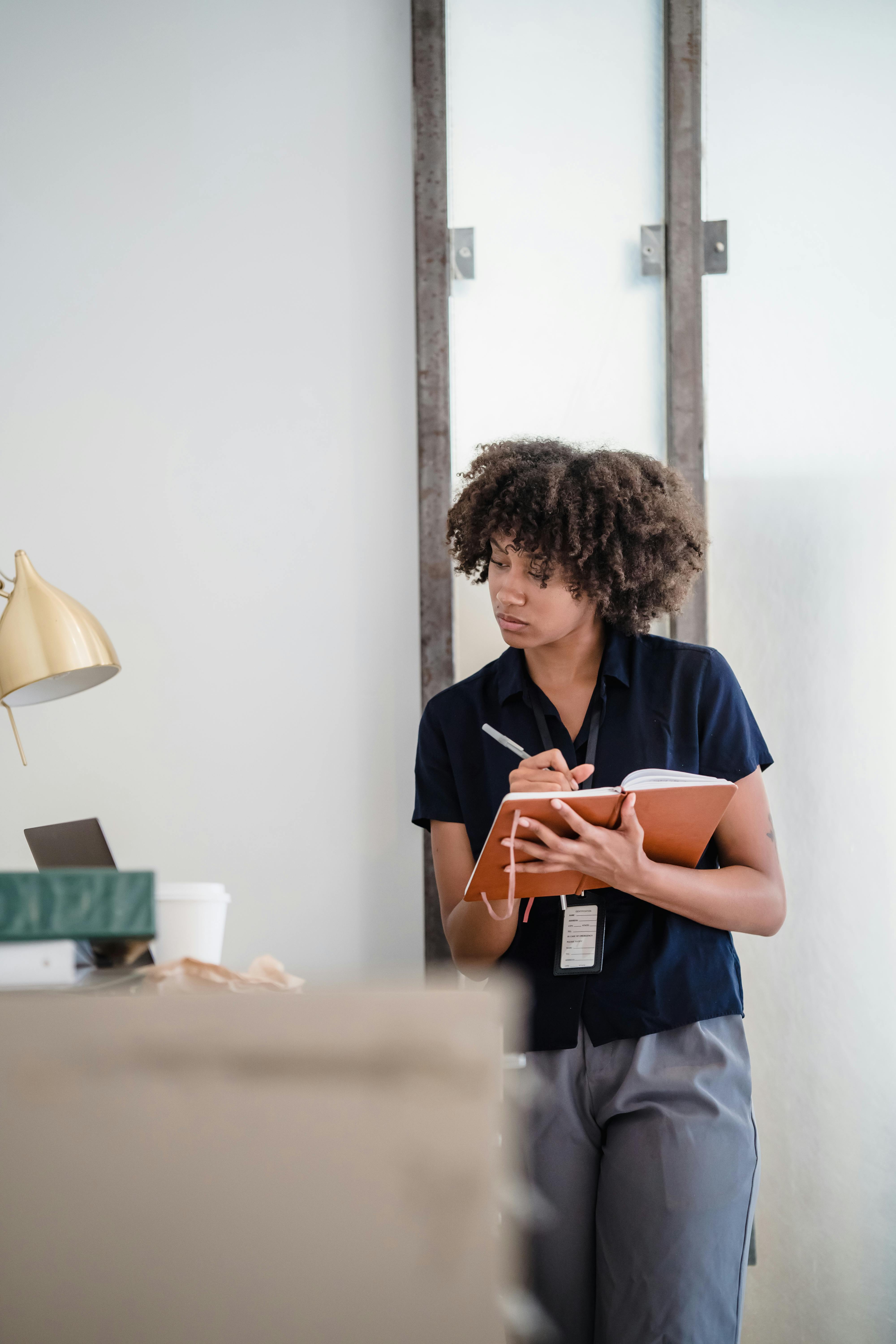 Woman Writing in a Notebook and Looking at a Laptop · Free Stock Photo