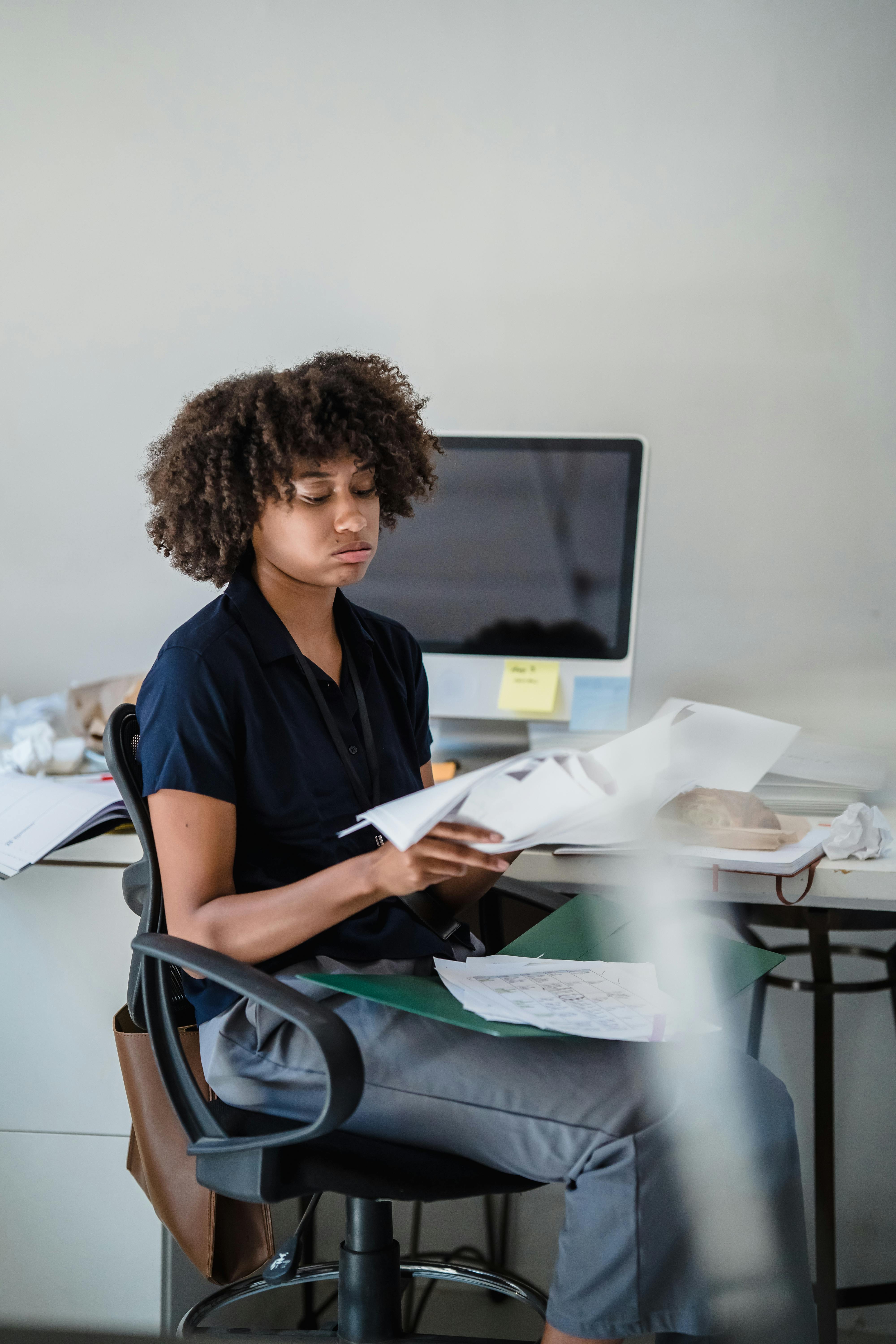 Female Office Worker Looking at Documents · Free Stock Photo