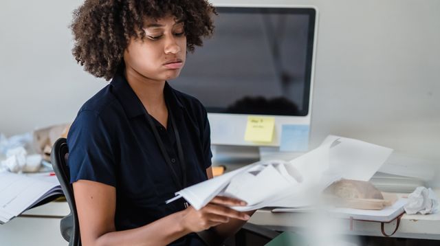 Woman reading documents at her office desk