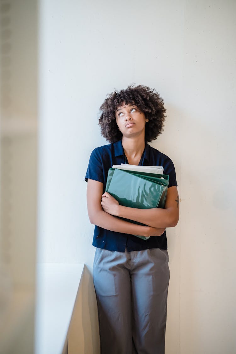 Female Office Worker With A Green Binder With Documents