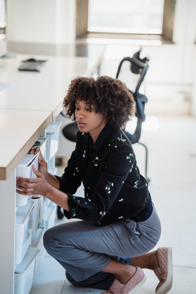 Businesswoman Searching For Documents In Boxes