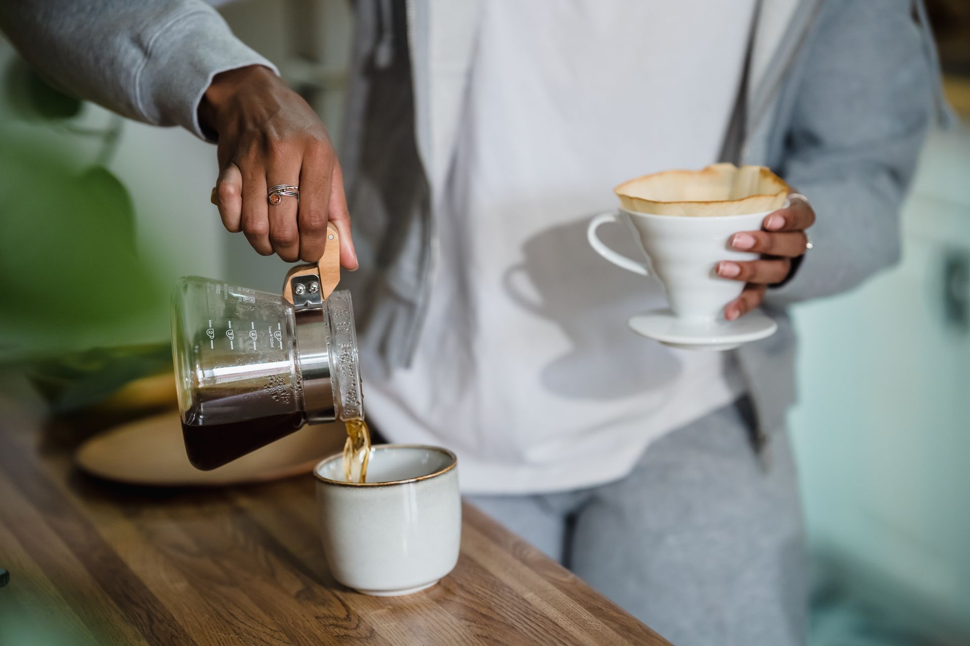 A close-up of a woman making coffee at home, capturing a cozy moment.